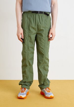 Green, lightweight, elastic waist cargo pants with side pockets and black belt. Paired with multicolored athletic shoes.