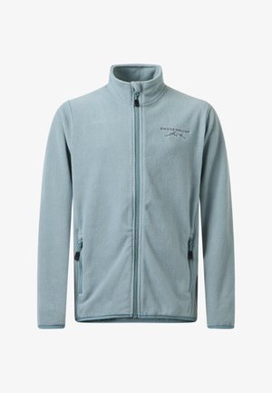 Veste softshell noire portée sur une polaire bleu clair, pantalon cargo noir et chaussures de randonnée noires. Les caractéristiques comprennent des fermetures éclair et des poches.