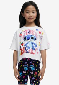 Camiseta blanca de manga corta con un gráfico colorido de Stitch, combinada con leggings azul marino con patrones florales y de dibujos animados.