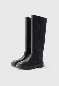 Černé kožené vysoké boty až ke kolenům s hladkým povrchem, kulatou špičkou a silnou platformou. Jednoduchý design bez výrazných vzorů či akcentů.