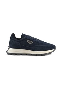 Scarpa sportiva in suede blu navy con suola bianca e nera, caratterizzata da un design snello e un accento metallico sul lato.