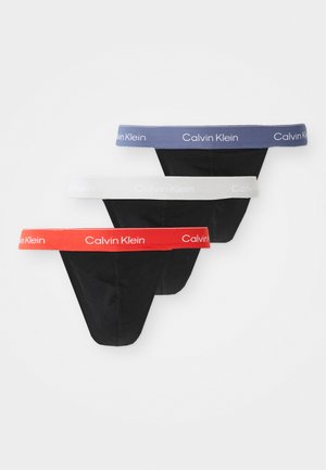 Trei perechi de chiloți negri cu benzi elastice contrastante în roșu, alb și albastru. Fiecare bandă elastică prezintă logo-ul "Calvin Klein".