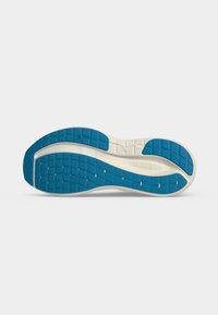 Semelle d'une chaussure de sport blanche avec des sections en caoutchouc bleu au talon, à l'avant-pied et aux orteils pour la traction.
