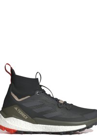 Basket de sport noire et grise avec un dessus en forme de chaussette, des matériaux texturés, des accents rouges au niveau du talon et une semelle intermédiaire blanche rembourrée.