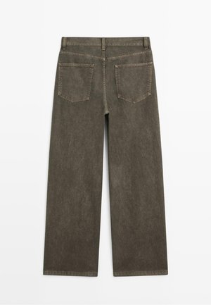 Jean large taille haute de couleur vert olive foncé avec une texture délavée et deux poches arrière, présentant des coutures visibles le long des ourlets.