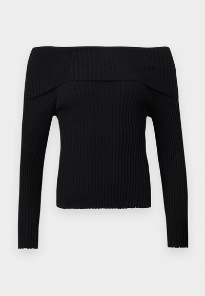 Zwarte ribgebreide trui met off-shoulder brede omgevouwen halslijn en lange mouwen, aansluitende silhouet tegen een effen lichtgrijze achtergrond.