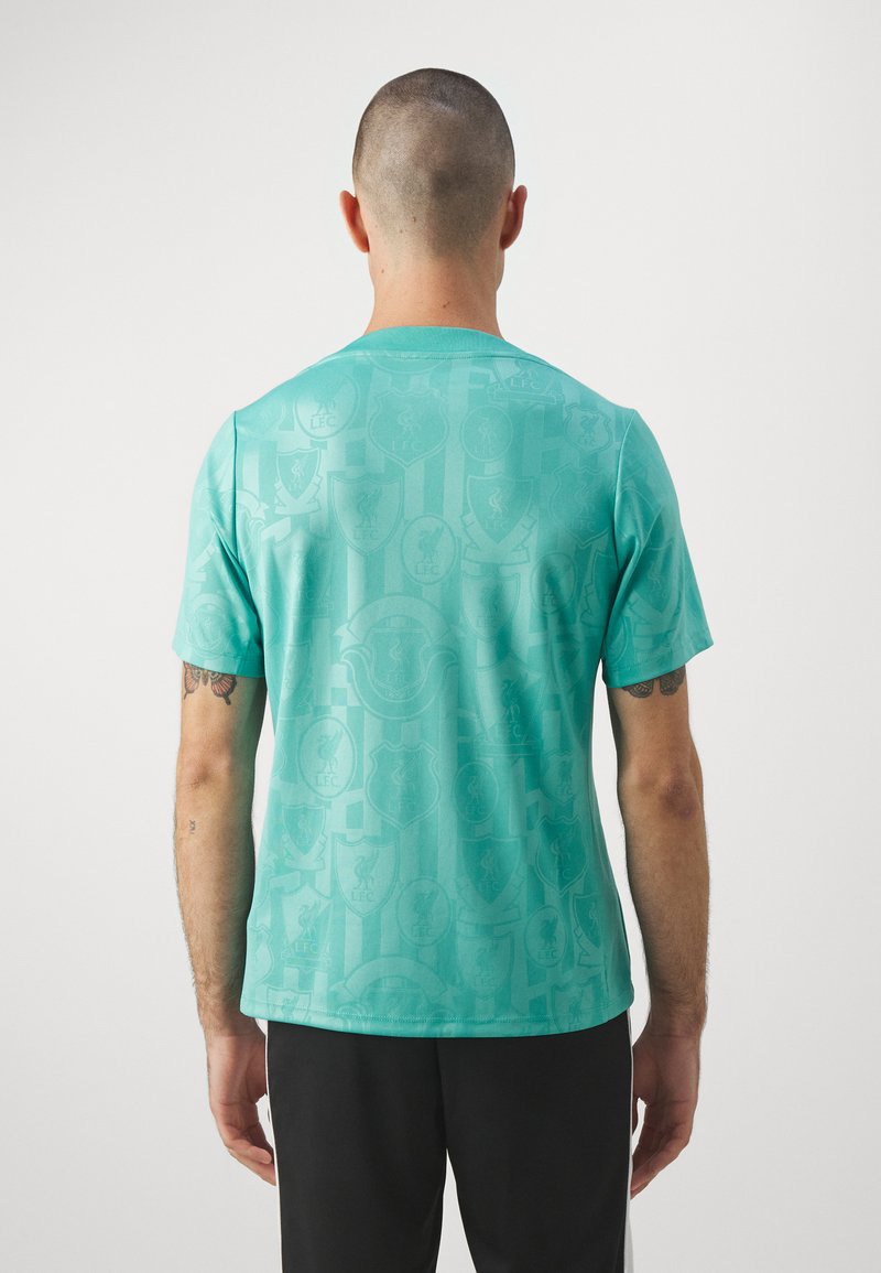 Camiseta turquesa de manga corta, con un sutil patrón de logotipos y escudos. Tejido ligero y escote redondo.