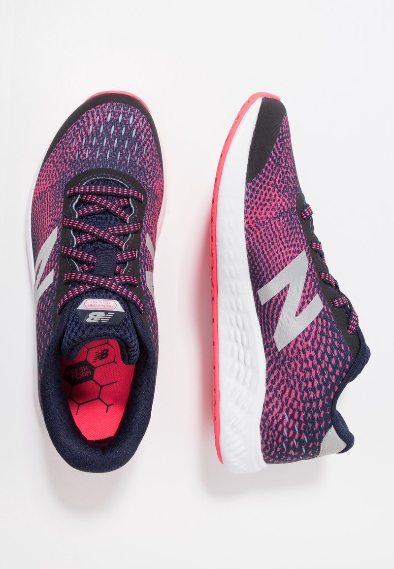 Běžecké boty s prodyšným vrškem z navy modré síťoviny s růžovými akcenty, černými tkaničkami a bílou mezipodešví s růžovou podrážkou. Stříbrný detail loga.