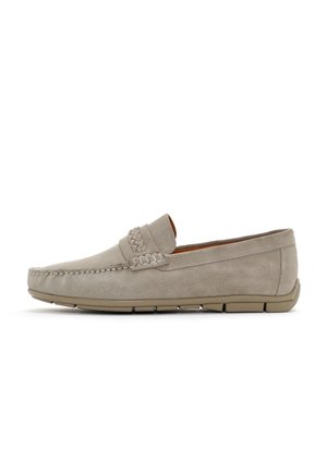 Mocasines de ante beige con detalle trenzado, punta redondeada y suela de goma flexible. Parte trasera ligeramente elevada y acentos de costura mínima.