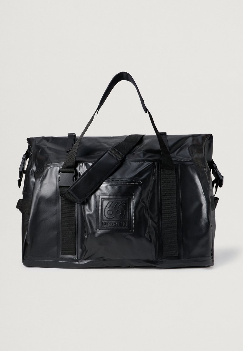 Mala de desporto preta, impermeável, com uma textura suave, alça de ombro ajustável, bolso lateral com fecho e pormenor de logótipo em relevo na frente.