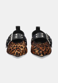 Mules de estampado de leopardo con puntera afilada, correas de piel negra con remaches plateados y una pestaña en la parte trasera para facilitar su uso. Acabado de textura suave.