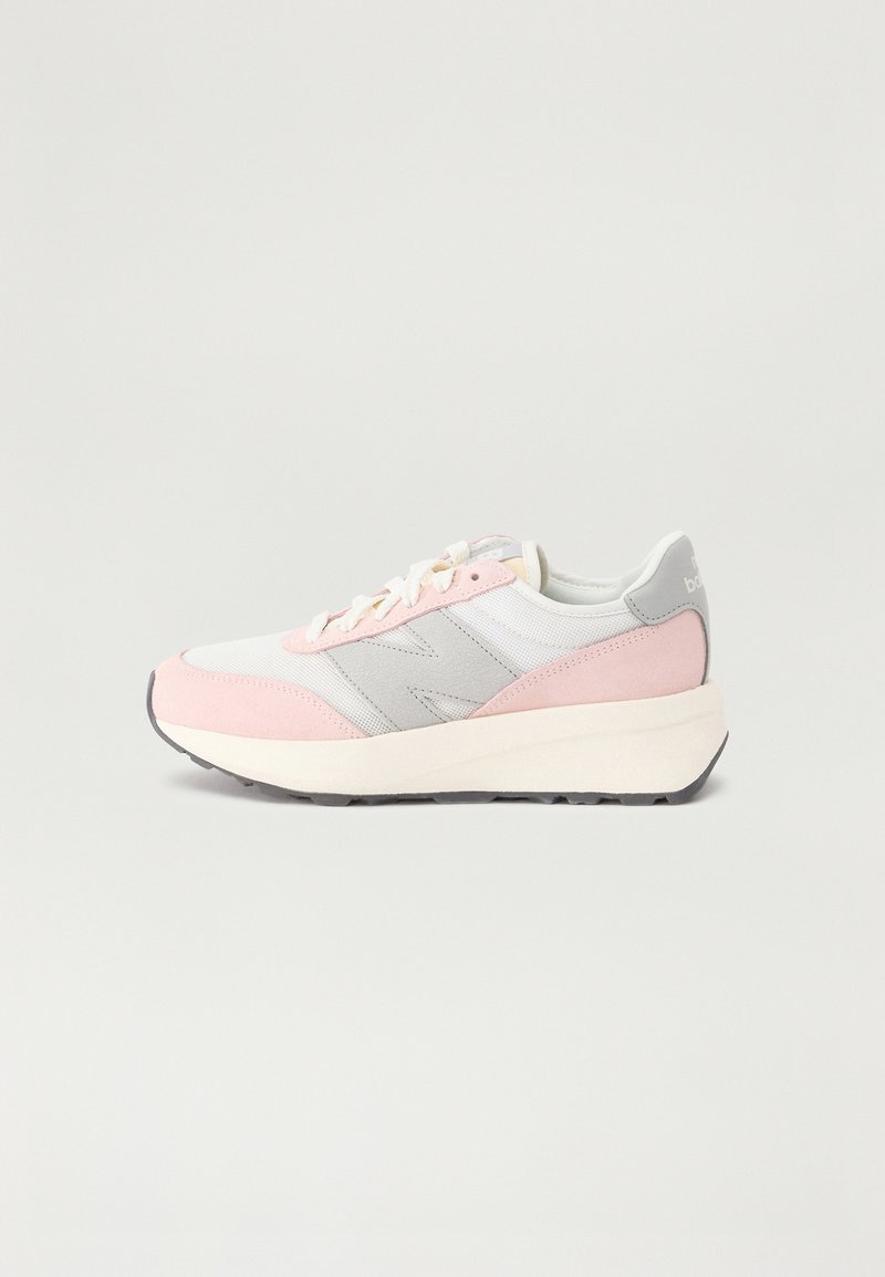 Baskets présentant un mélange de tissu blanc, de surpiqûres en suède rose et d'accents gris. Semelle épaisse et rembourrée avec une bande de roulement noire. Design incurvé.