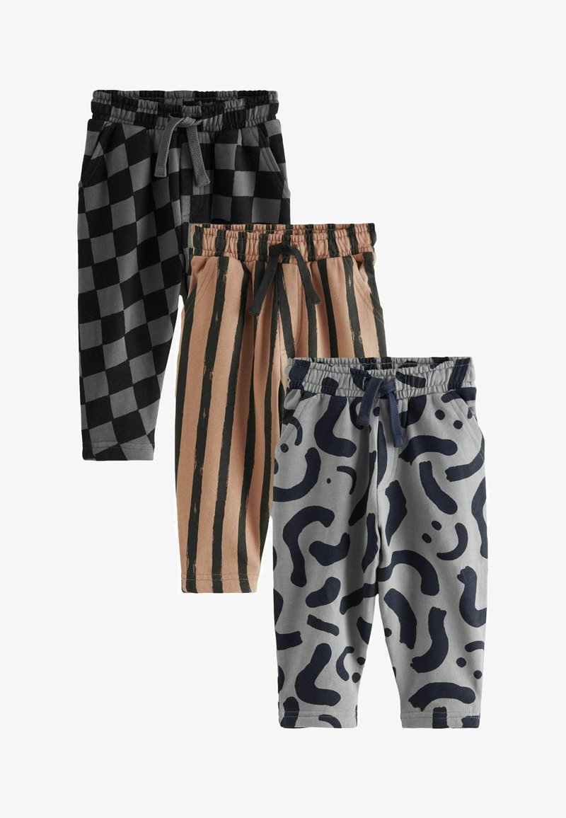 Tre paia di pantaloni della tuta: a scacchi neri, beige con strisce nere verticali e grigi con motivi astratti blu navy. Tutti hanno bande elastiche in vita.