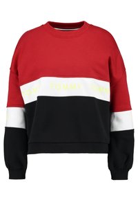 Felpa rossa e nera con accenti bianchi e gialli, caratterizzata da una forma squadrata, collo a girocollo a costine e grafica "TOMMY" sulla fascia frontale.