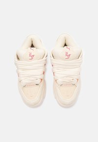 Bežist sneakersid, millel on tekstureeritud kitsel ja sileda naha detaile. Omavad silmapaistvaid paelu, logodetaile ja peeneid roosa акtsente.