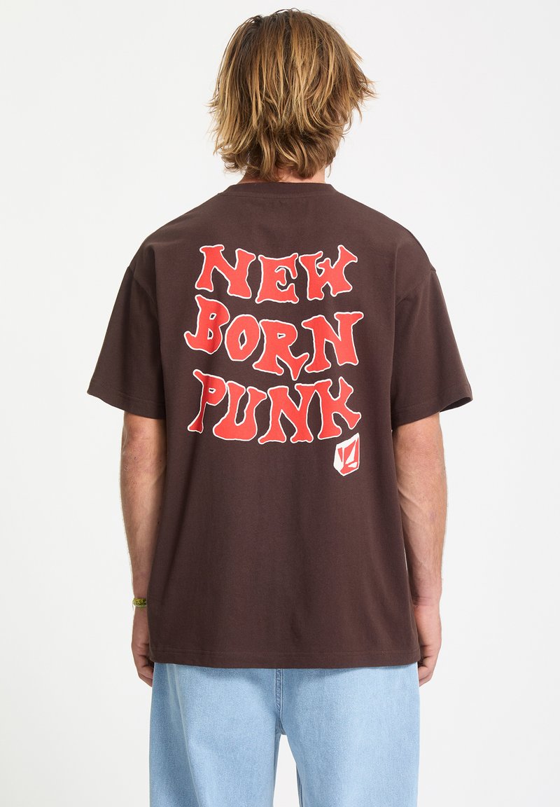 Brun bomulds-T-shirt med stort rødt grafisk tekst "NEW BORN PUNK" på ryggen. Korte ærmer og en afslappet pasform.