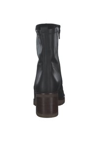 Black leather ankle boot with a rounded toe, side zipper, and a brown stacked heel. Features visible stitching along the seams.
