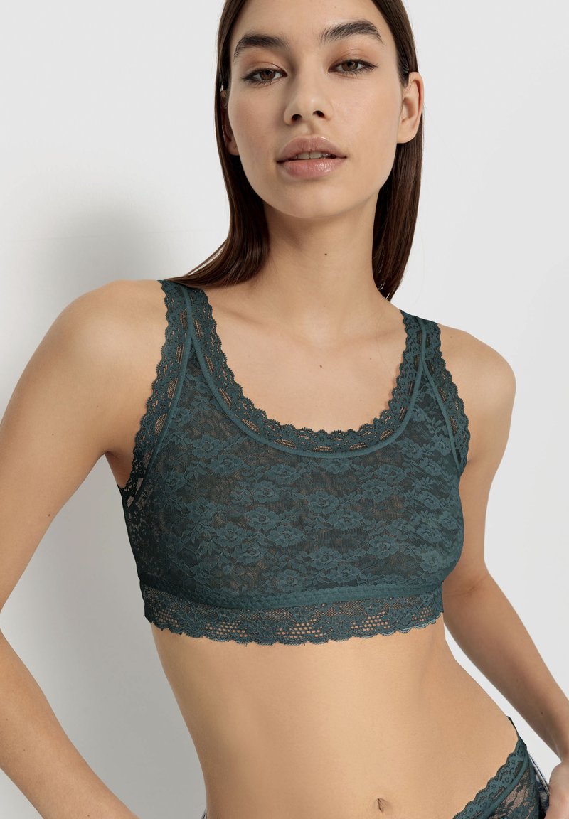 Teal kanten bralette met golvende randen, ingewikkeld bloempatroon en een getailleerd ontwerp. Zachte textuur met verstelbare schouderbanden.