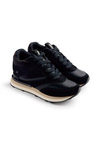 Sneaker sportive nere con una combinazione di suede e materiali lisci. Punta arrotondata, suola intermedia bianca piatta e suola esterna in gomma testurizzata.