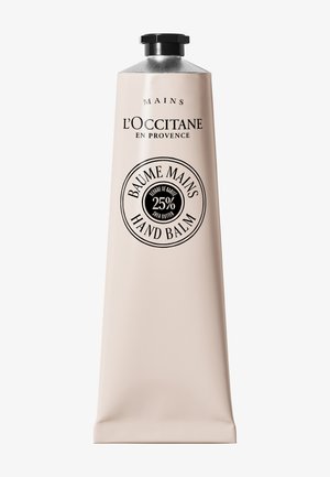 Tubetto di balsamo per le mani L'Occitane con il 25% di burro di karité, confezione beige, tappo nero, etichettato in francese e inglese.