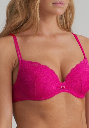 Pink lace bra with padded cups, floral pattern, adjustable straps with a smooth finish, and a small metal clasp at the center front.
