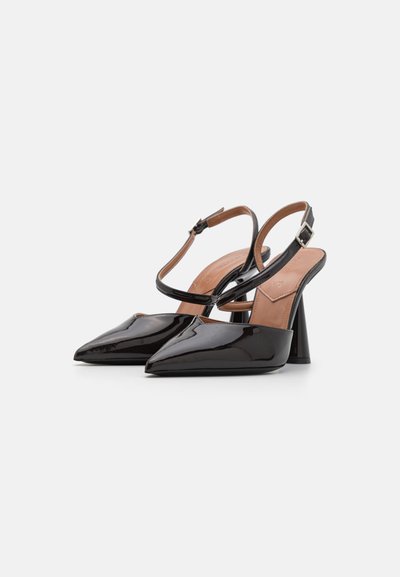 Sorte patentlæder slingback hæle med spidse tæer og en kraftig hæl. Har en tynd ankelrem med en sølvspænde.