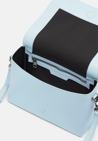 Borsa in pelle azzurro chiaro con interno in tessuto nero, tasca con zip e tracolla removibile; texture liscia e forma rettangolare.