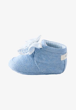 Morbida scarpa da bambino blu con tessuto trapuntato, grande fiocco a righe sulla parte superiore e fodera interna imbottita a quadretti.