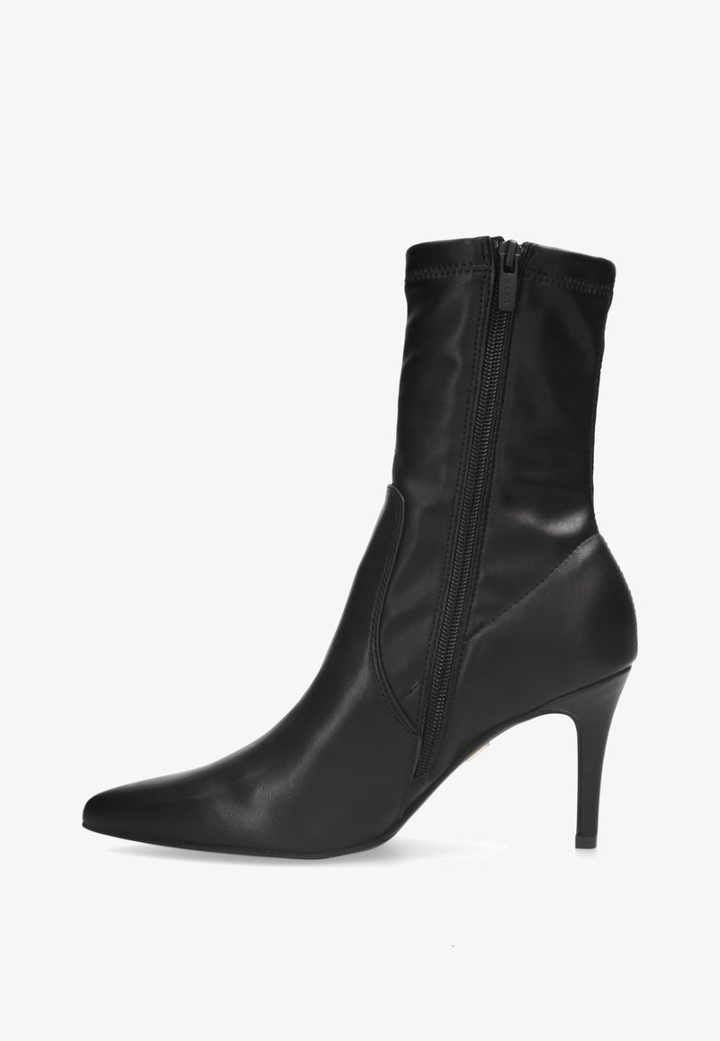 Bottine en cuir noir avec bout pointu, fermeture éclair latérale et talon stilettos sur fond blanc.