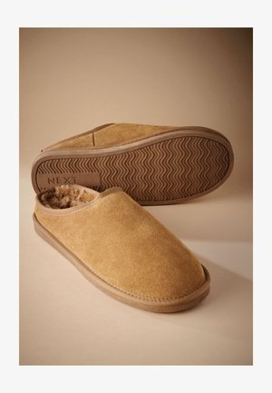 Chaussons marron en daim à enfiler avec une doublure en polaire douce et une semelle en caoutchouc texturée, un chausson montrant la semelle avec le logo "NEXT".