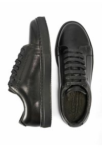 Czarne skórzane sneakersy o gładkim wykończeniu, okrągłym czubku, płaskiej gumowej podeszwie i sześciu oczkach na sznurowadła. Wnętrze ma teksturowane wykończenie.