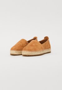 Espadrilles en suède à enfiler, de couleur beige, avec un bout arrondi, une semelle en jute et une finition texturée. Elles présentent des coutures minimalistes et une semelle flexible.