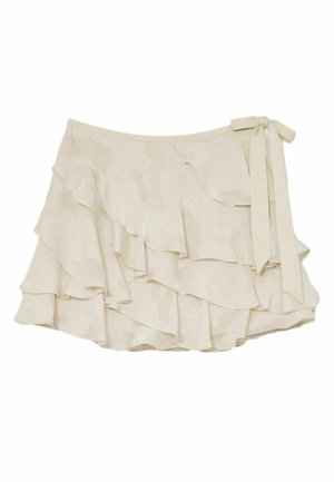 Krém színű, réteges mini szoknya oldalsó masnival és puha fodros anyagtextúrával.