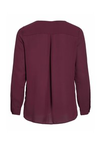 Blusa bordeaux a maniche lunghe con scollatura rotonda, dettaglio a pieghe sul retro e polsini con bottoni. Tessuto dalla trama liscia.