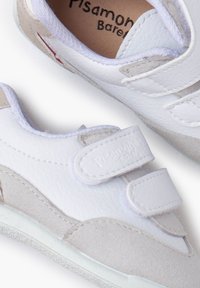 Witte leren en suède peuterschoenen met klittenbandsluitingen en een zachte rubberen zool. Gladde textuur met afgerond ontwerp en subtiele kleuraccenten.