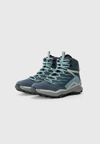 Blauwe wandelschoenen met grijze accenten, textuurstof en lichte zool. Kenmerken omvatten een versterkte neus, gevoerde kraag en veilige veters.