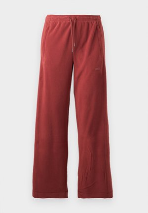 Red fleece pants with a wide-leg design, elastic waistband, and drawstring. Features side pockets and a small logo detail.