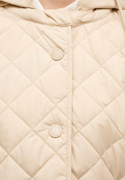 Μπεζ καπιτονέ μπουφάν με κουκούλα, με μοτίβο διαμαντιού και δύο κυκλικά κουμπιά με την επιγραφή "WEEKEND". Ομαλή υφή και ελαφρύς σχεδιασμός.