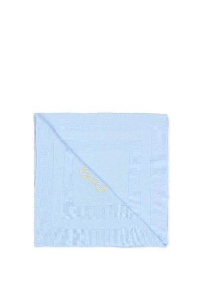 Copertina per bambini azzurra chiaro lavorata a maglia, piegata diagonalmente con motivi quadrati testurizzati e una piccola forma di osso giallo ricamata al centro.