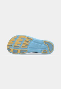 Semelle de chaussure de sport avec une base en caoutchouc bleu flexible et un motif de grip jaune, comportant des éléments texturés pour la traction et la stabilité.