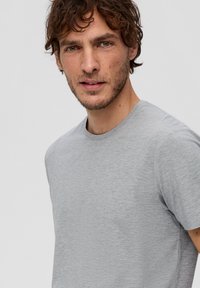 Grijze crew-neck t-shirt met korte mouwen, gemaakt van zachte stof. Kenmerkt zich door een gladde textuur en een subtiele gemêleerde patroon.
