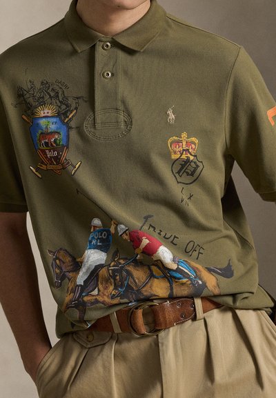 Πράσινο ελαιώδες πόλο πουκάμισο με κεντημένα μοτίβα πόλο, ασπίδες και παίκτες επάνω σε άλογα· διαθέτει κουμπωτή λωρίδα και μπεζ ζώνη.