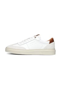 White sneaker with leather and suede accents, tan heel, flat laces, round toe, and textured sole with a light-colored midsole.