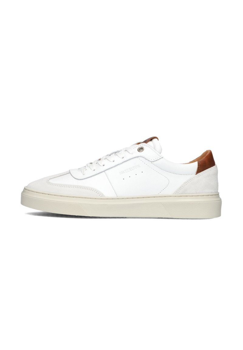 White sneaker with leather and suede accents, tan heel, flat laces, round toe, and textured sole with a light-colored midsole.