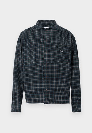 Camisa de botão em flanela azul escura com um padrão em quadrados brancos e laranja. Apresenta colarinho e um bolso no peito com detalhe do logótipo.