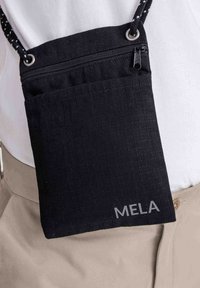 Zwarte stoffen crossbody tas met een gestructureerd oppervlak, voorzien van een ritsluiting en het logo "MELA" aan de voorkant. Korte, gestreepte schouderband.