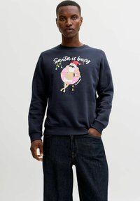 Námořnická mikina s grafikou znázorňující Santy v brýlích na růžovém donutovém plováku, s textem "Santa je zaneprázdněn" a barevnými světelnými řetězy.