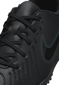 Scarpe da calcio nere con tomaia in pelle testurizzata, lacci neri e un design elegante. Presenta un sottile logo Nike nero sul lato.