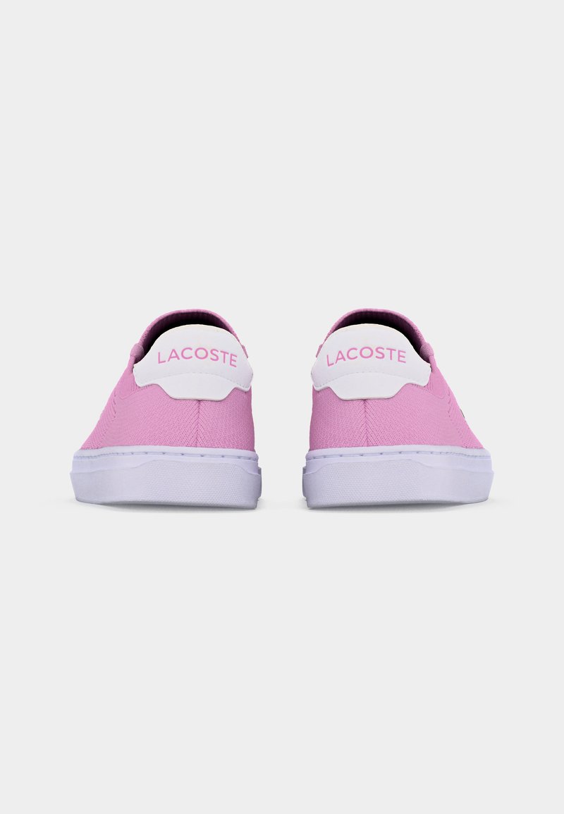 Paar rosa Lacoste Low-Top-Sneaker mit weißen Sohlen und weißen Fersenlaschen, von hinten auf einem einfarbigen Hintergrund betrachtet.