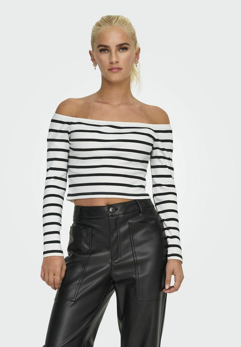 Czarna i biała, paskowana, odkryta ramiona bluzka crop top z prążkowanej tkaniny, zestawiona z czarnymi spodniami z ekoskóry o wysokim stanie z przednimi kieszeniami.